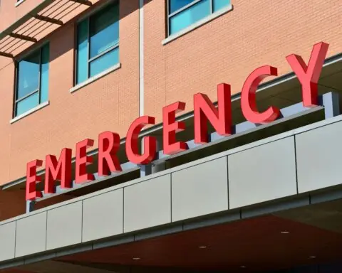 An image of an emergency sign outside of a red brick building.