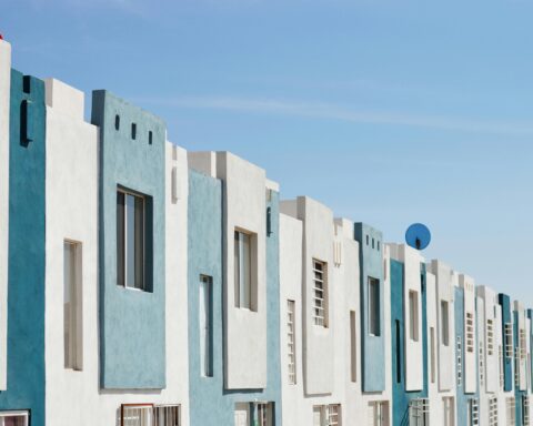 White and teal affordable housing complex from the outside.