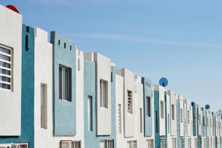 White and teal affordable housing complex from the outside.