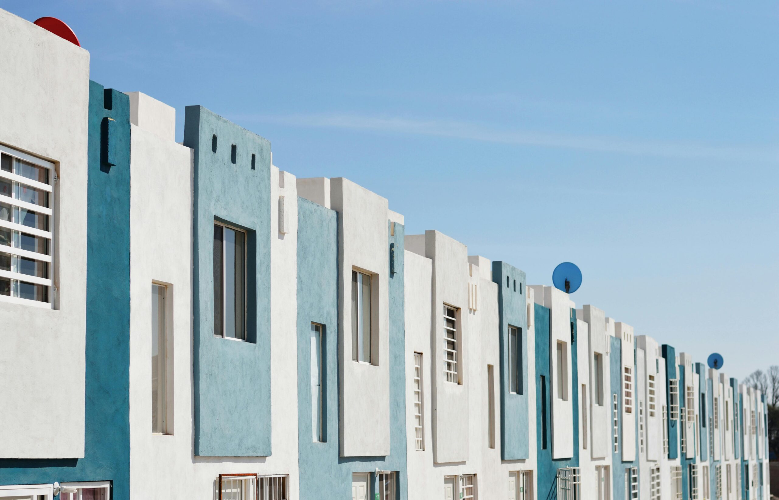 White and teal affordable housing complex from the outside.