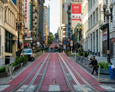 A blocked off street in San Francisco with space for buses, commercial vehicles, trolleys and safety pedestrian access.