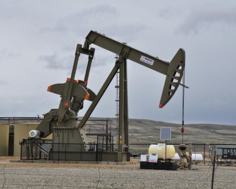 An oil extractor in an empty field extracting oil and gas from the ground.