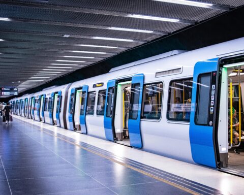A rail system with passengers stopped at a station.