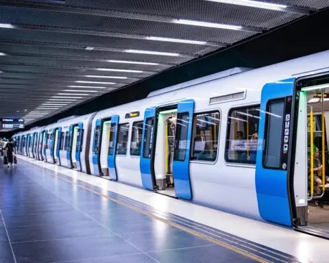 A rail system with passengers stopped at a station.