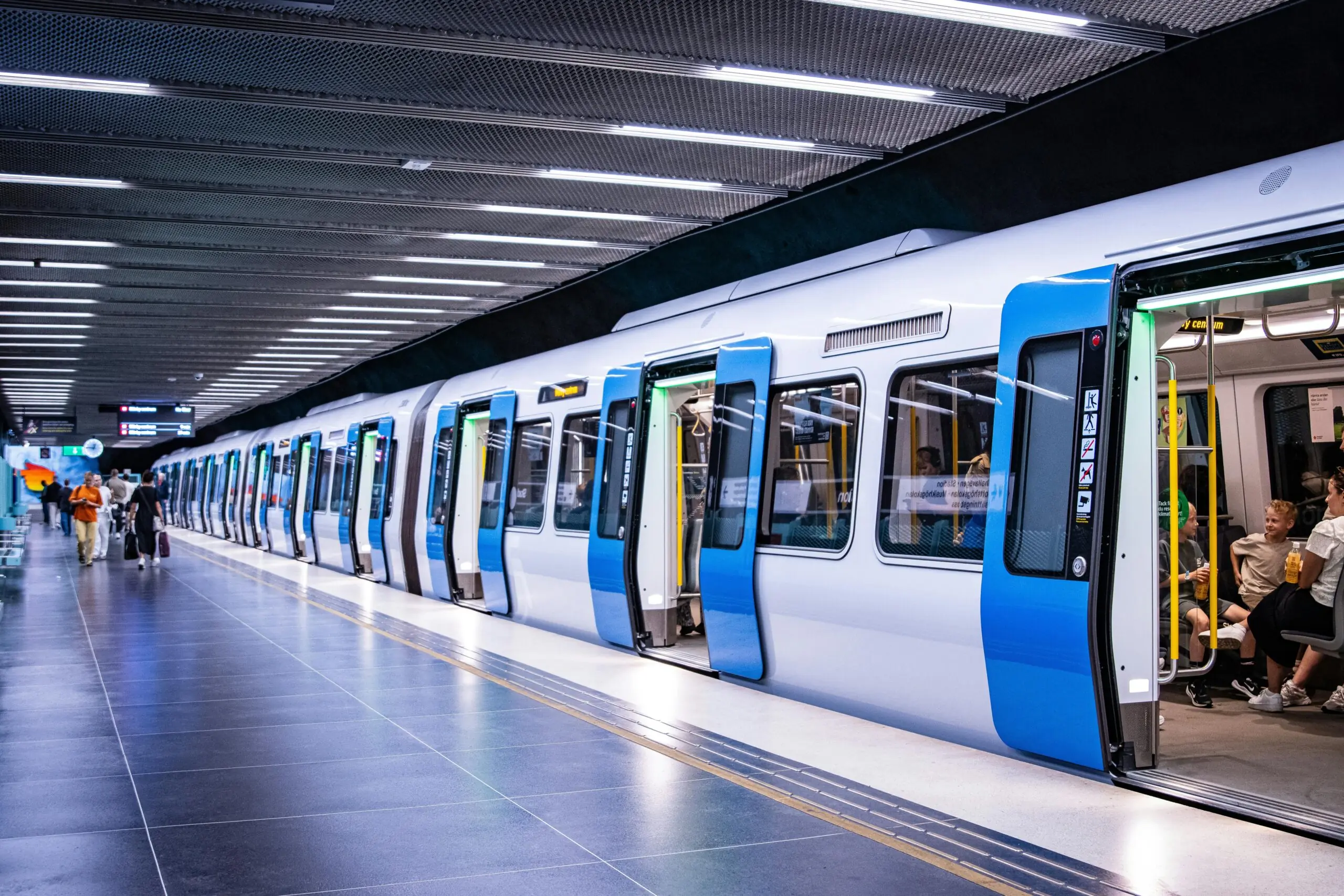 A rail system with passengers stopped at a station.