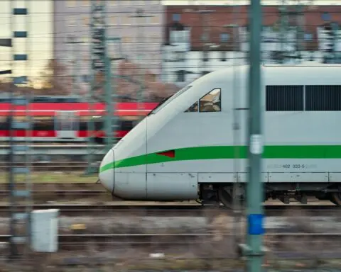 A high-speed locomotive moves along train tracks.