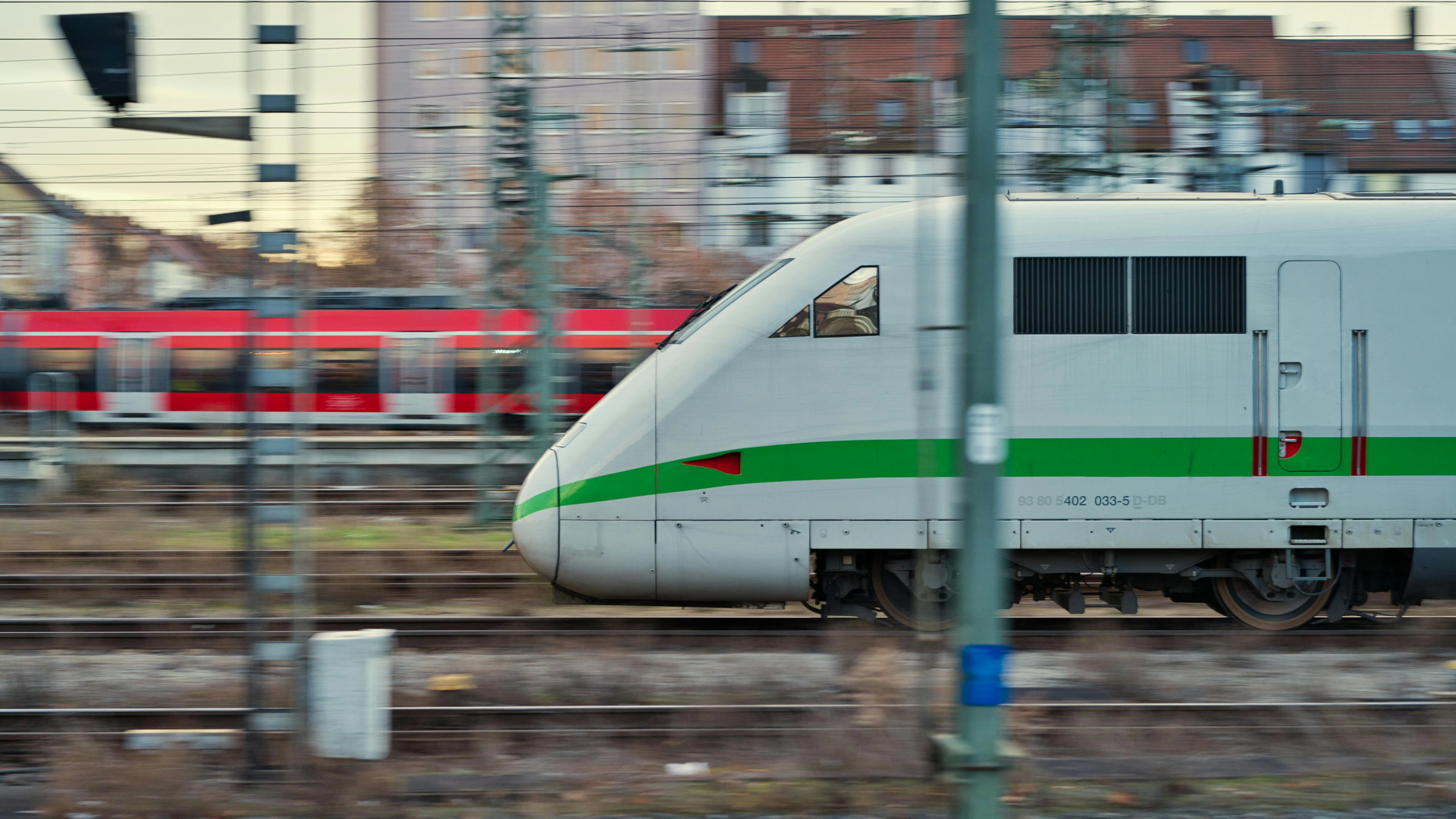 A high-speed locomotive moves along train tracks.