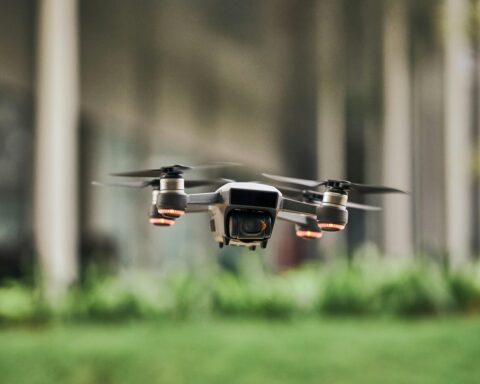 A drone hovers above a grassy field.