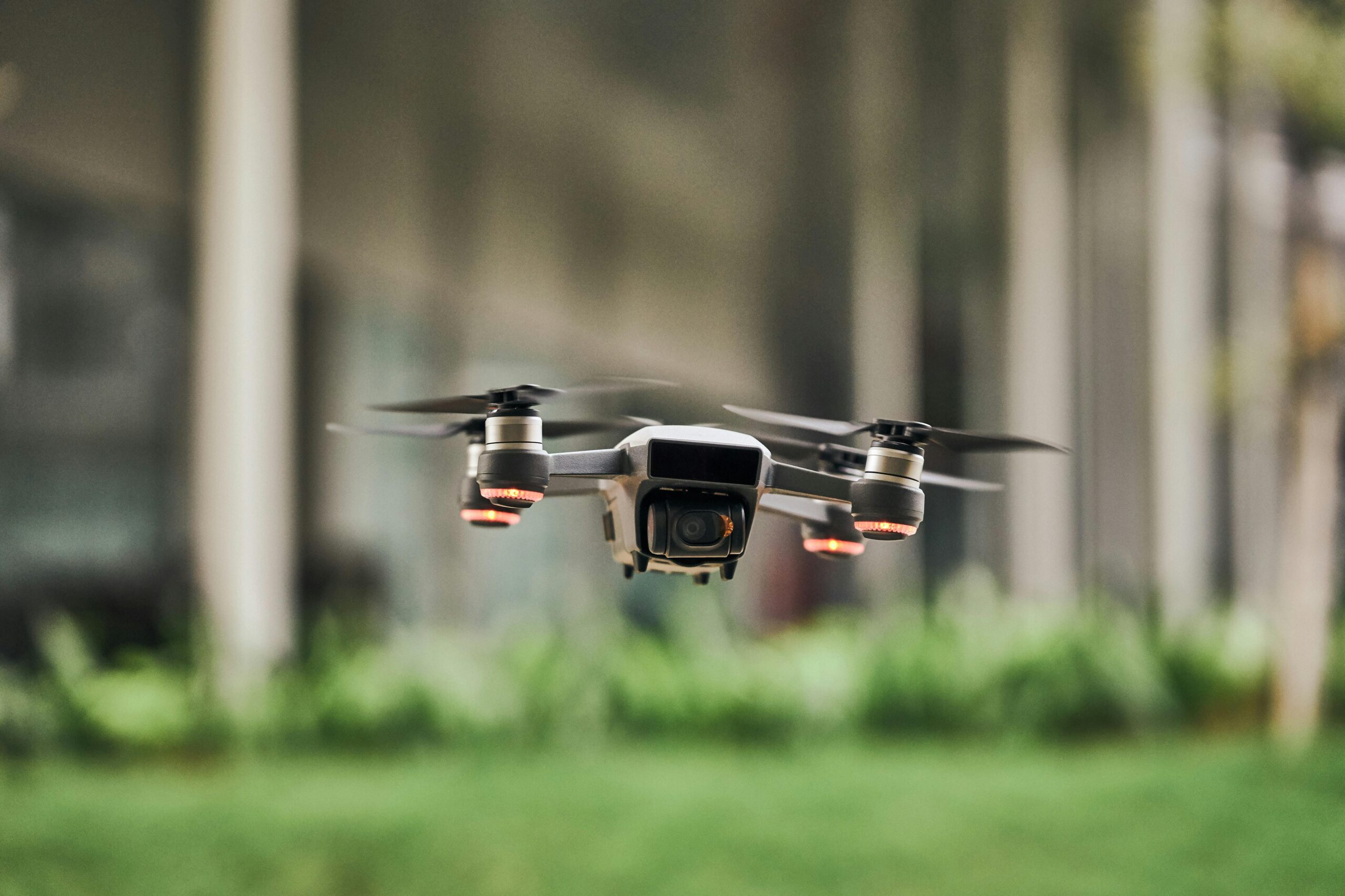 A drone hovers above a grassy field.