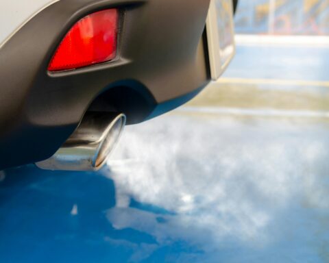 A silver vehicle's exhaust pipe emits greenhouse gases.