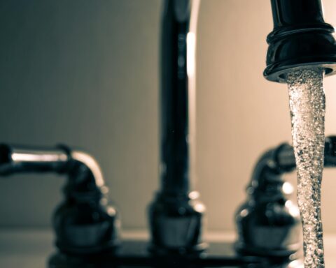 Water pours from a faucet on a sink.