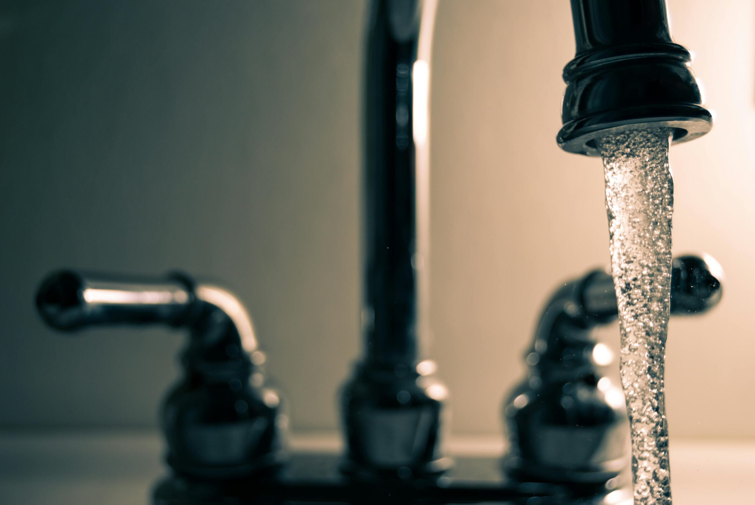 Water pours from a faucet on a sink.