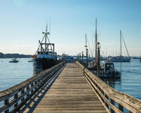 A wooden dock with connected ships at Port Jefferson on Long Island in New York.