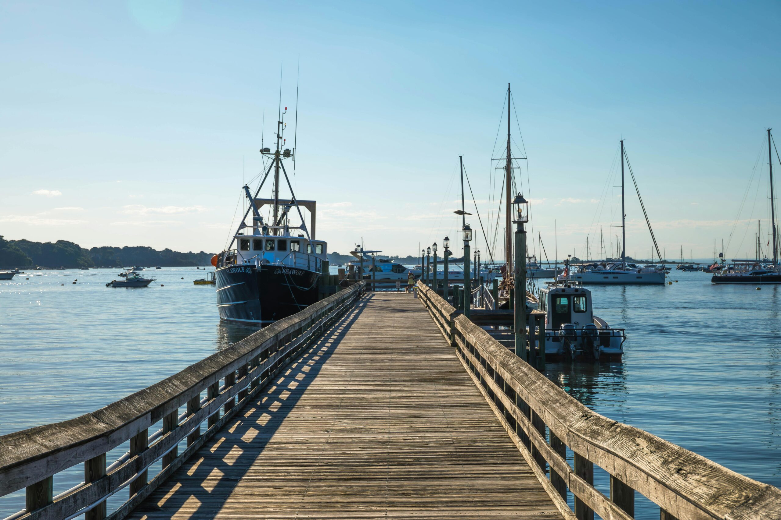 A wooden dock with connected ships at Port Jefferson on Long Island in New York.