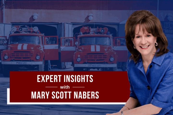 Mary Scott Nabers before fire trucks and a fire station for her weekly column.