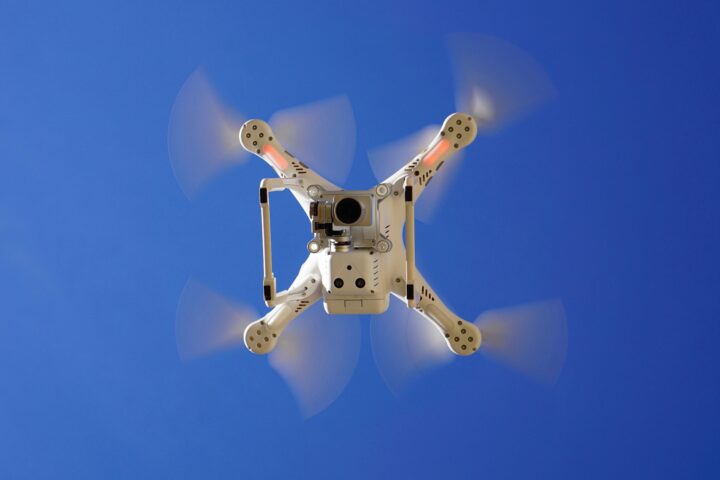 The underside of a flying drone with a camera.