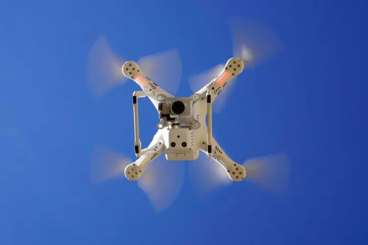 The underside of a flying drone with a camera.