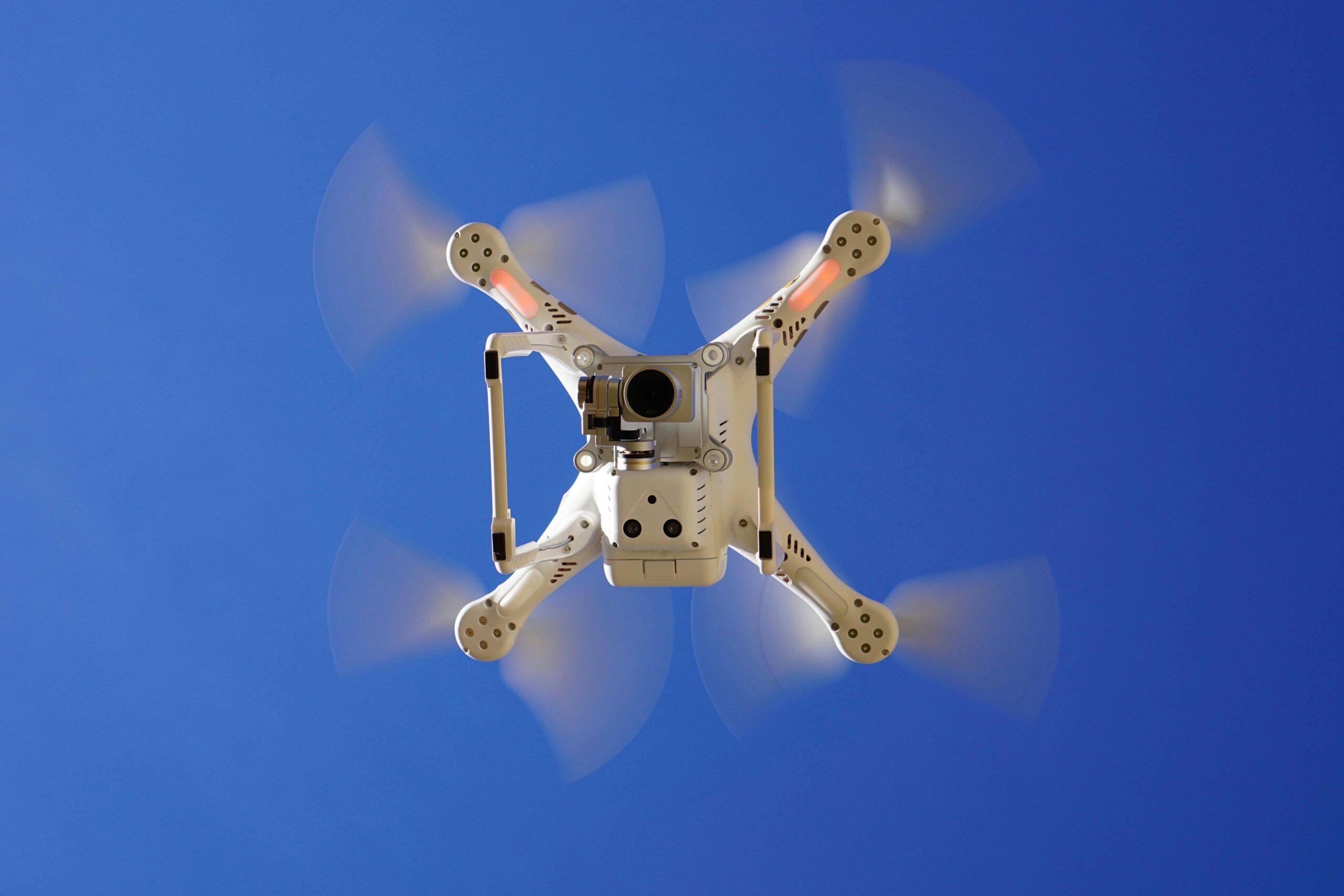The underside of a flying drone with a camera.
