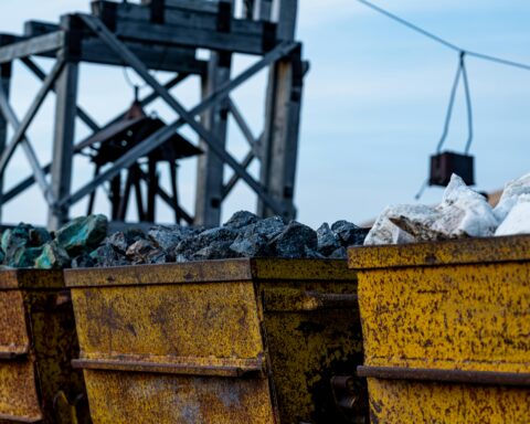 Mining carts carry critical minerals nearby a mining site.