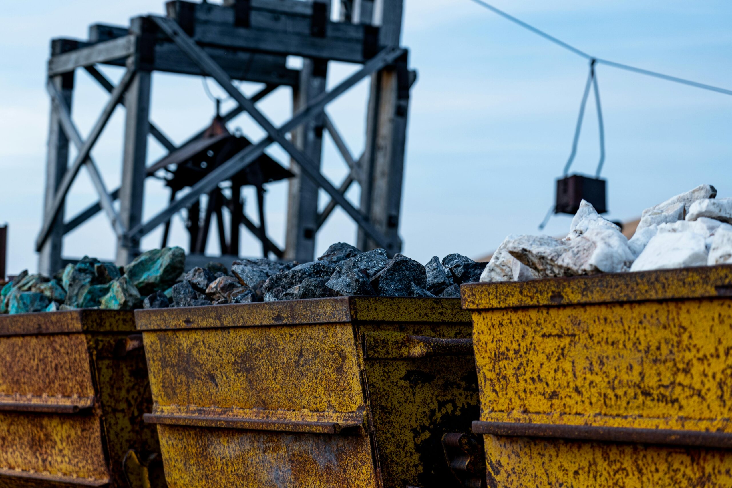 Mining carts carry critical minerals nearby a mining site.