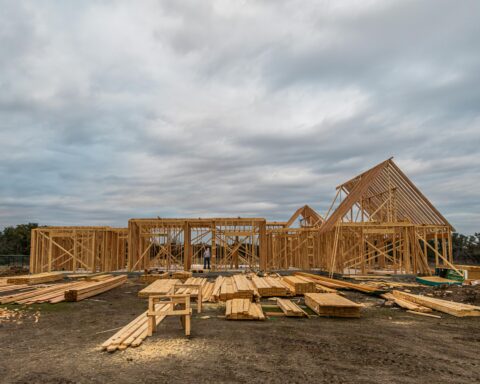 A housing development before distant trees and a cloudy sky.
