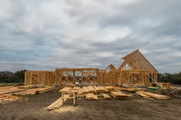 A housing development before distant trees and a cloudy sky.
