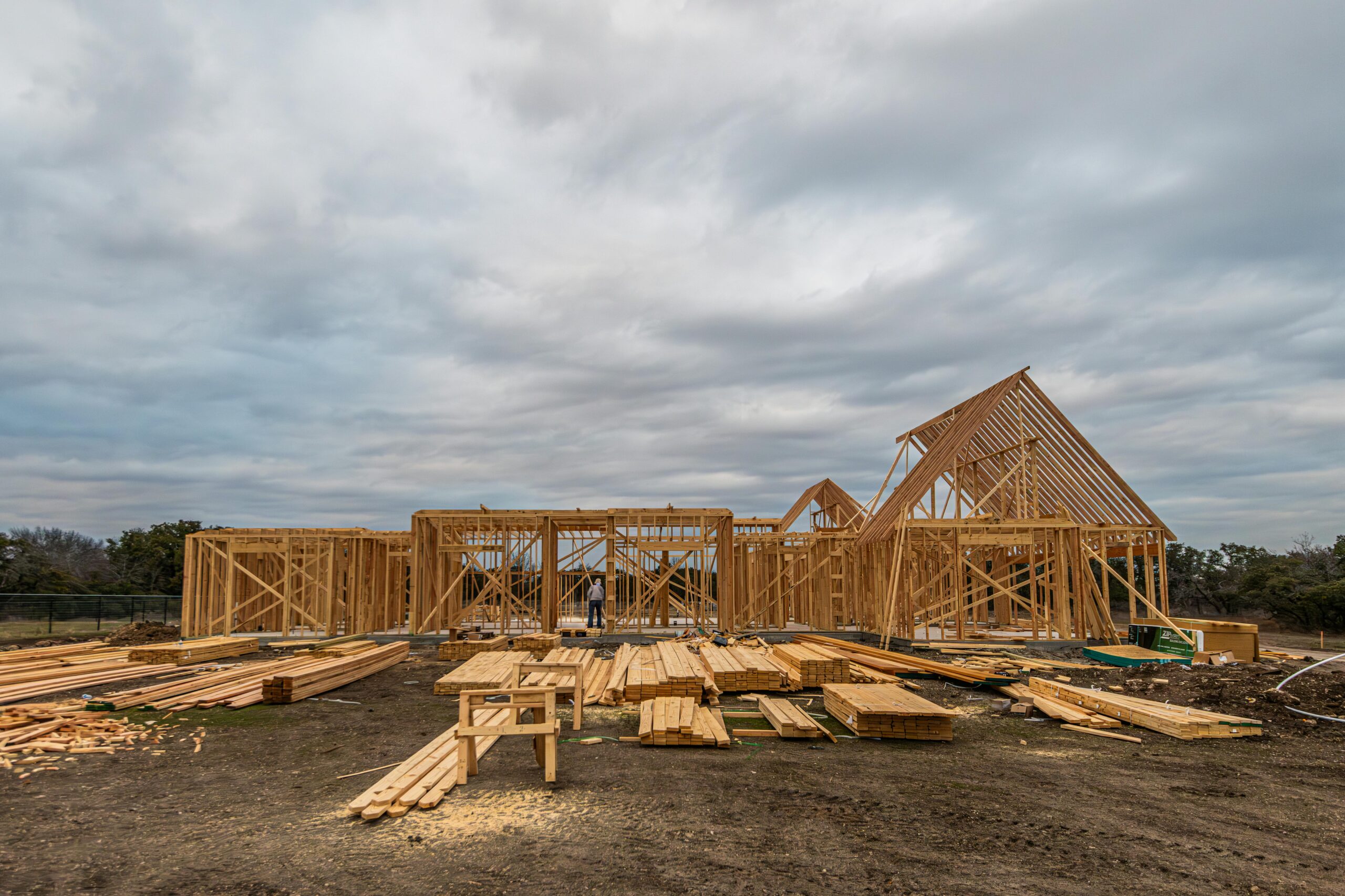 A housing development before distant trees and a cloudy sky.