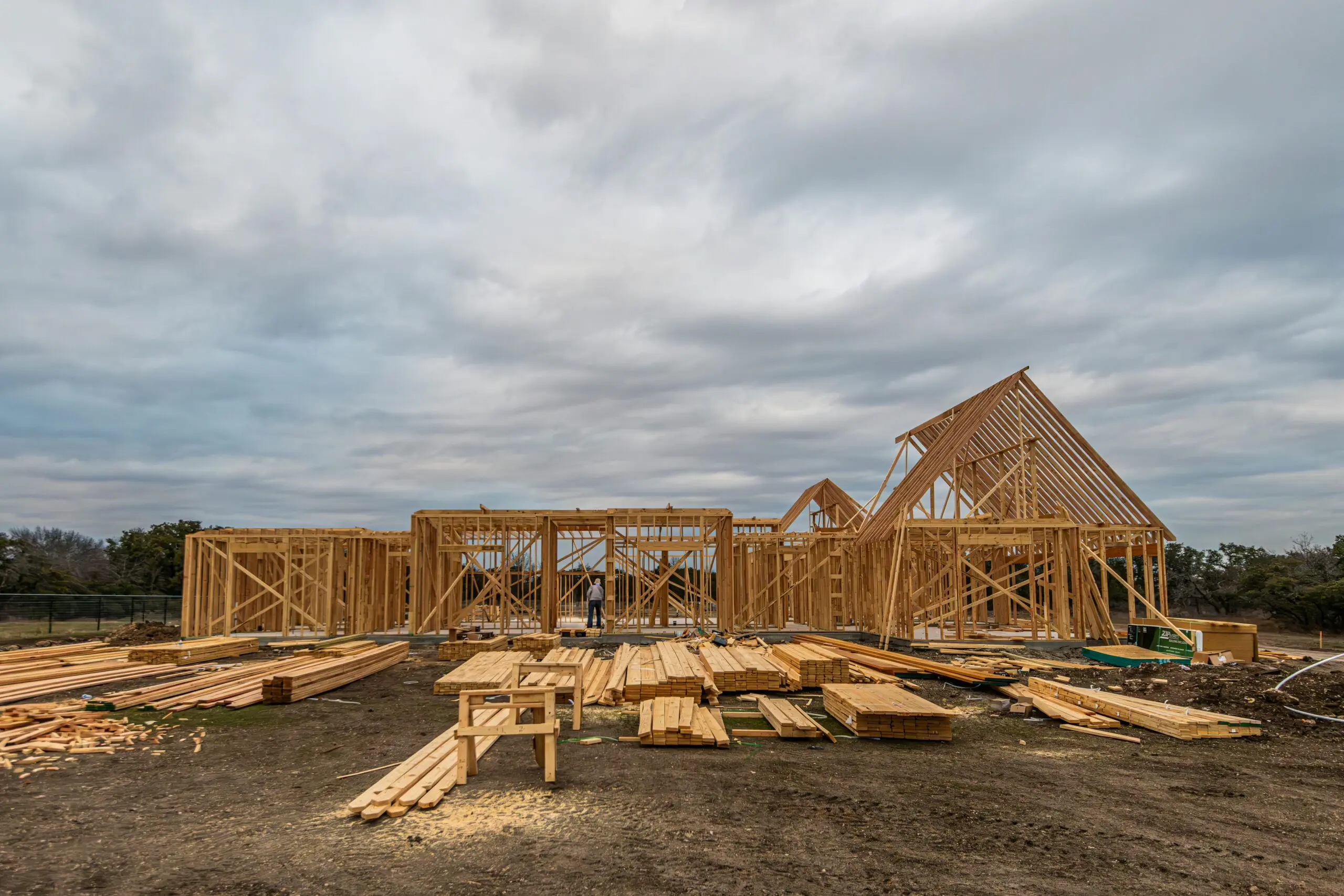 A housing development before distant trees and a cloudy sky.