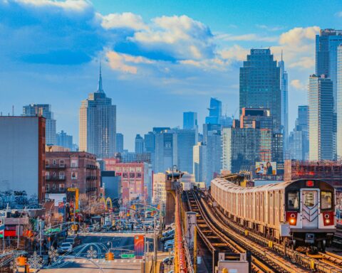 A train passes down elevated tracks in New York City.