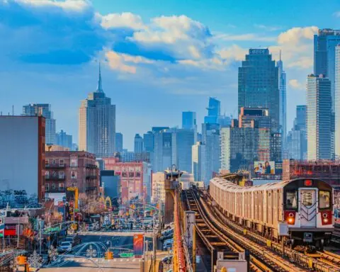A train passes down elevated tracks in New York City.