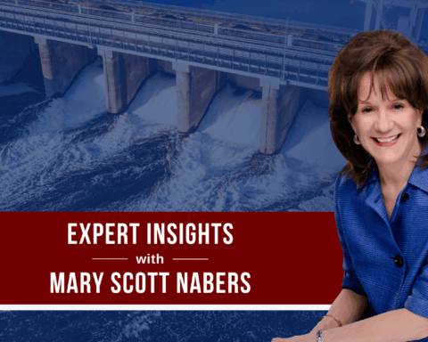 Mary Scott Nabers before a hydroelectric power plant for her weekly column.
