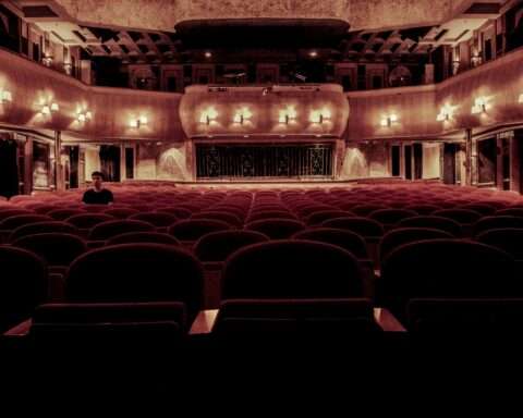 An empty theater with seats and balconies from the stage.