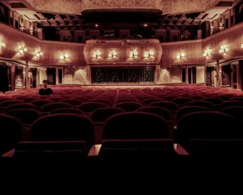 An empty theater with seats and balconies from the stage.