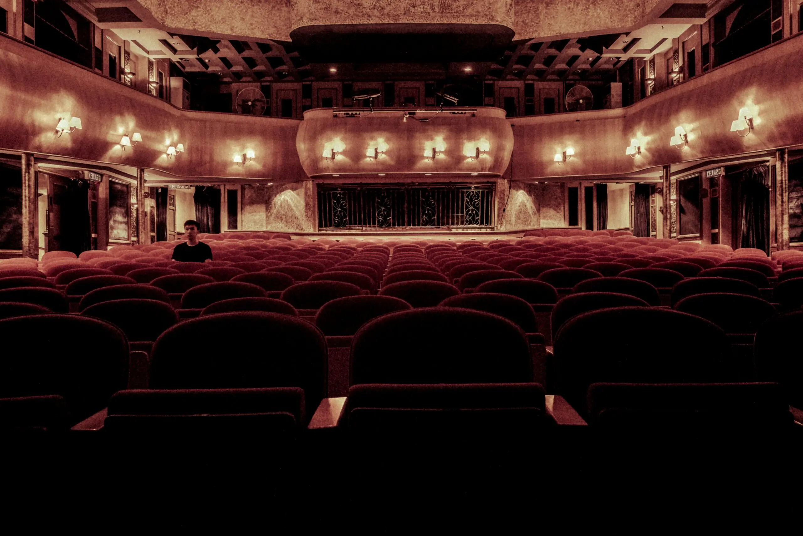 An empty theater with seats and balconies from the stage.