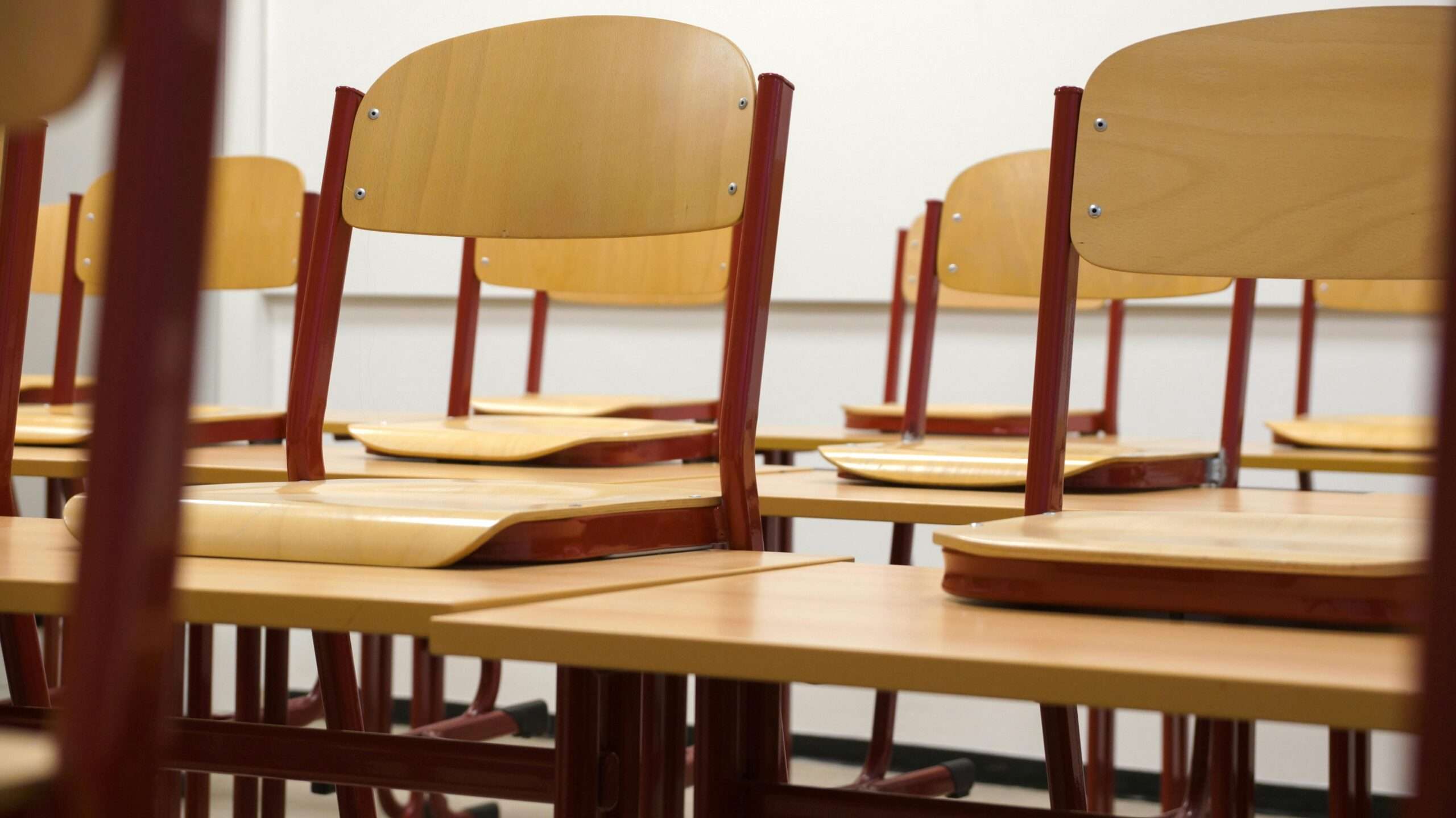 Classroom desks in a well-lit classroom.