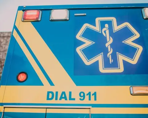 The side of an ambulance that says DIAL 911 alongside a medical system.