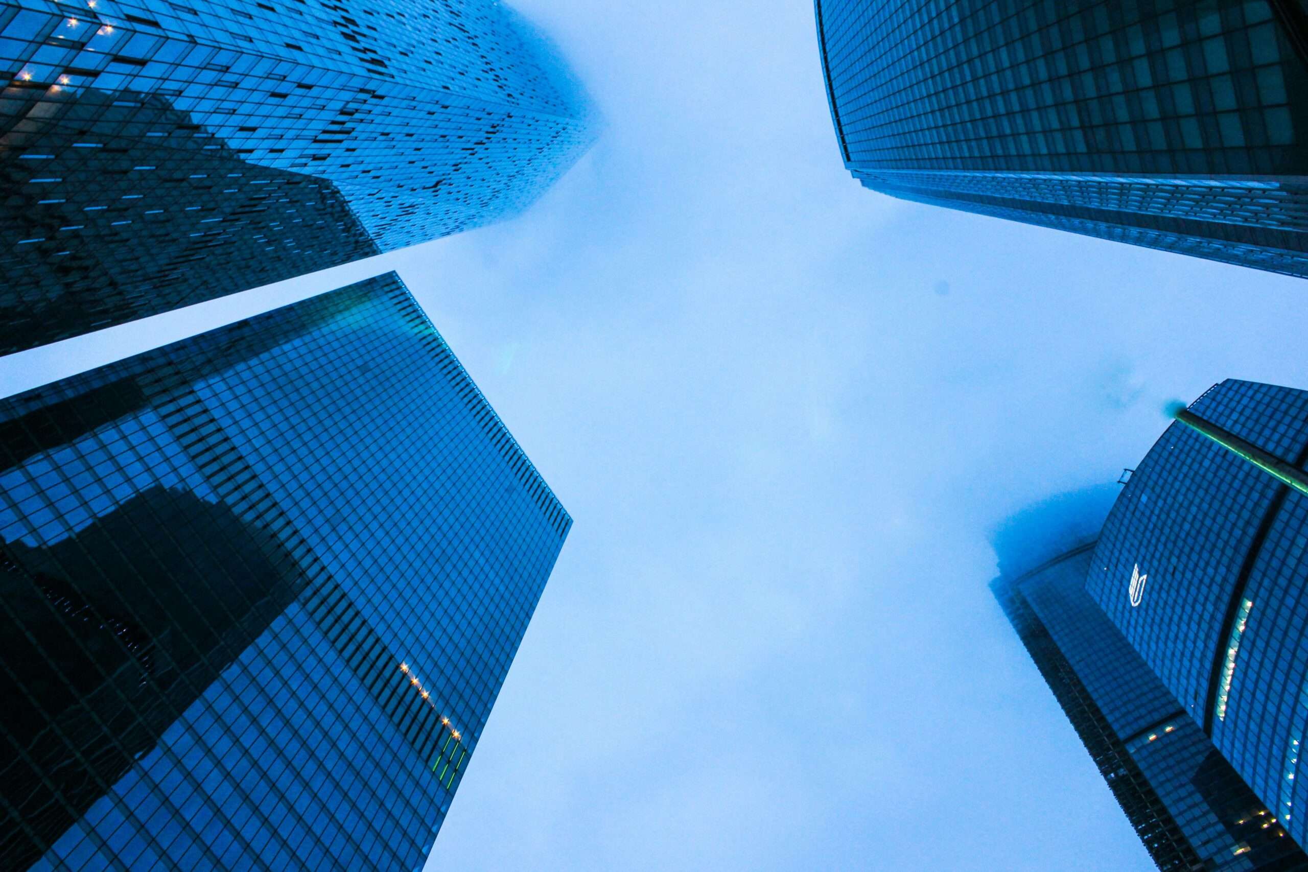 Skyscrappers raise into a deep blue cloudy sky.
