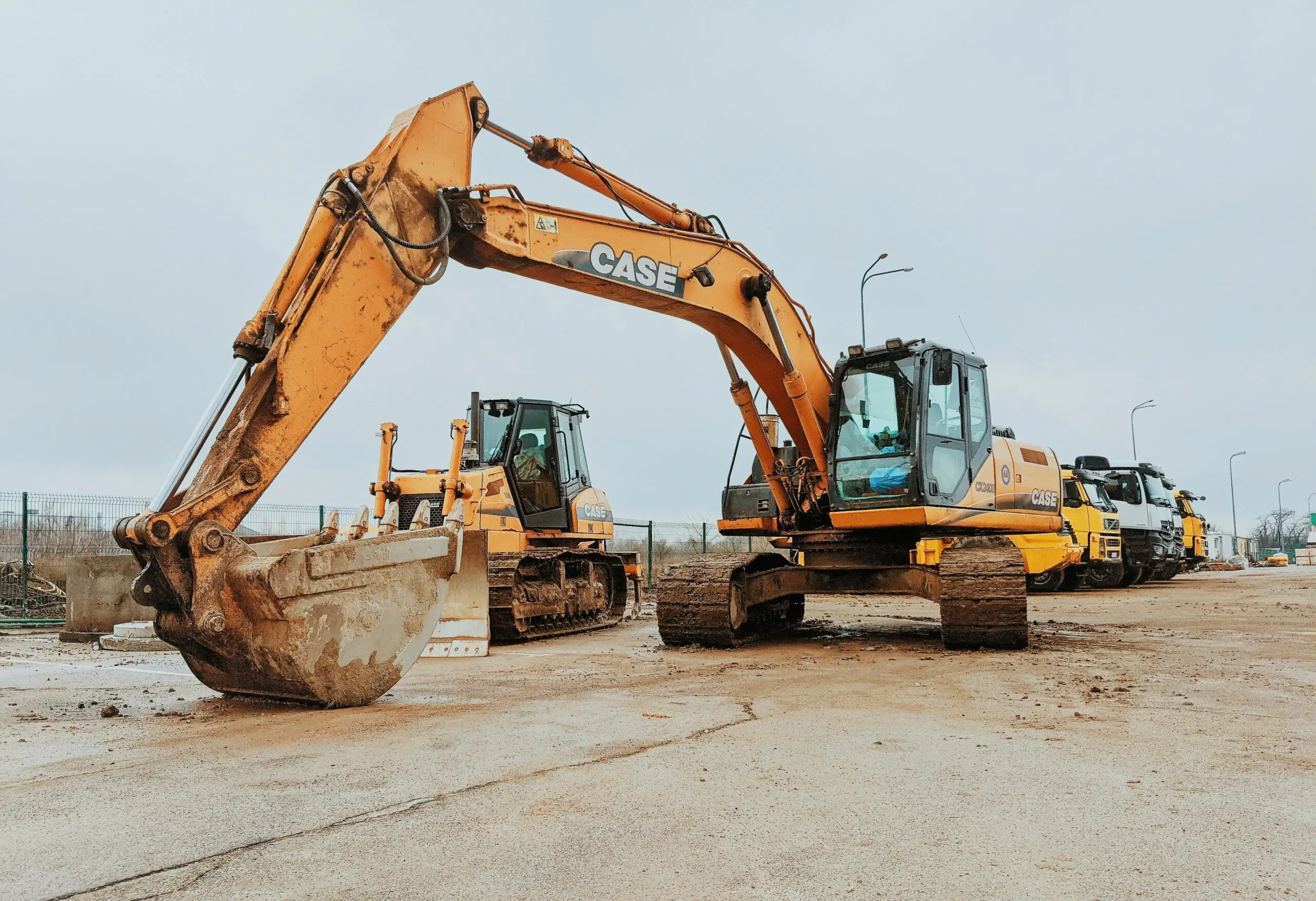 An excavator and a bulldozer on a dirt path prepared to construct something.
