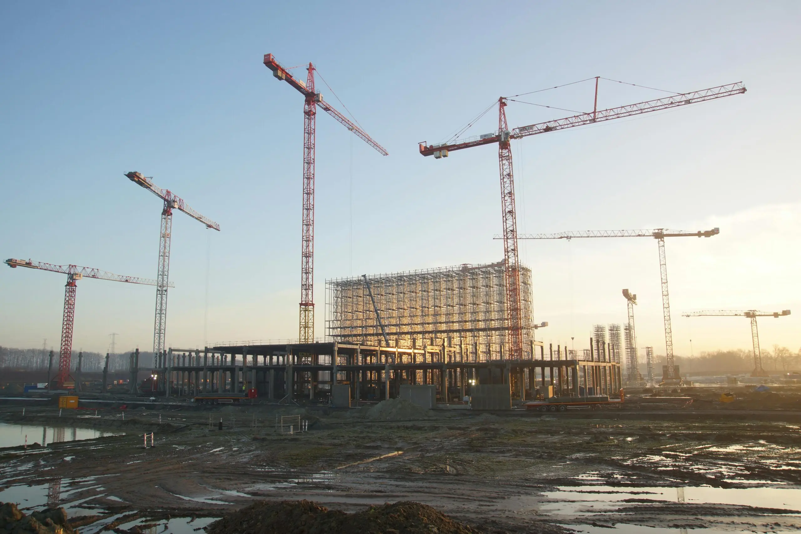 A large construction site with several cranes towering above the site.