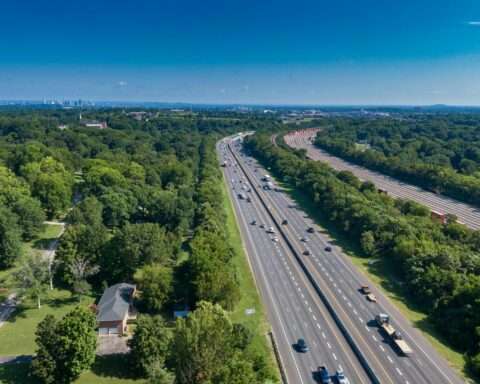 An aerial view of an American highway with cars and semi trucks on the road.