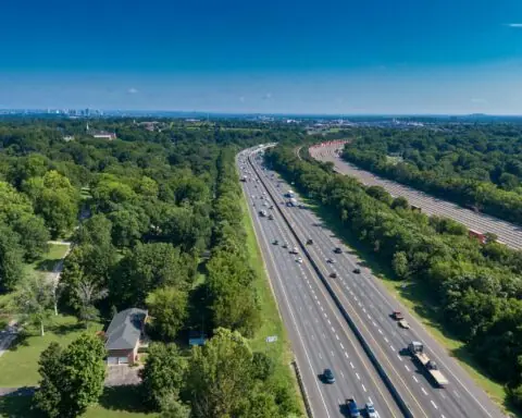 An aerial view of an American highway with cars and semi trucks on the road.