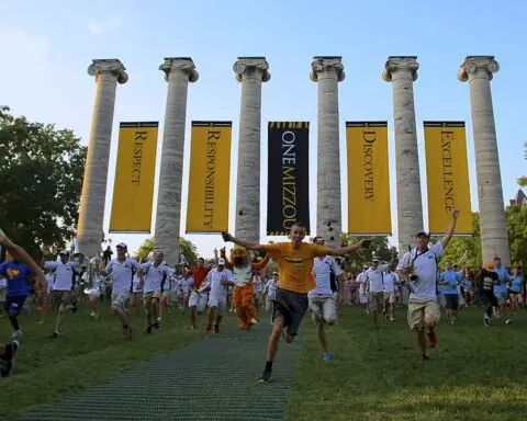 Students run through pillars at the University of Missouri.