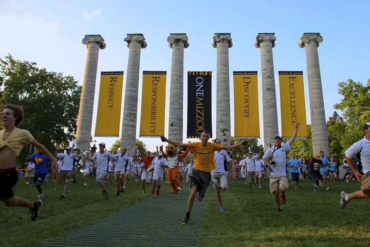 Students run through pillars at the University of Missouri.