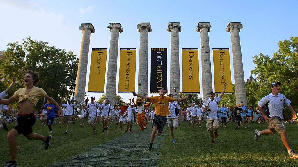 Students run through pillars at the University of Missouri.