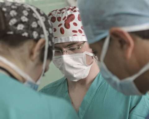 Three medical professionals stand among each other.