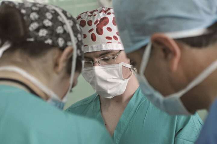 Three medical professionals stand among each other.