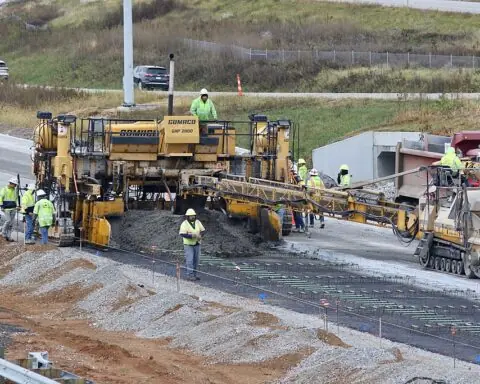 A paving machine along a highway.