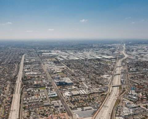An angled aerial view of Los Angeles highways and neighborhoods.