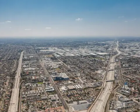 An angled aerial view of Los Angeles highways and neighborhoods.