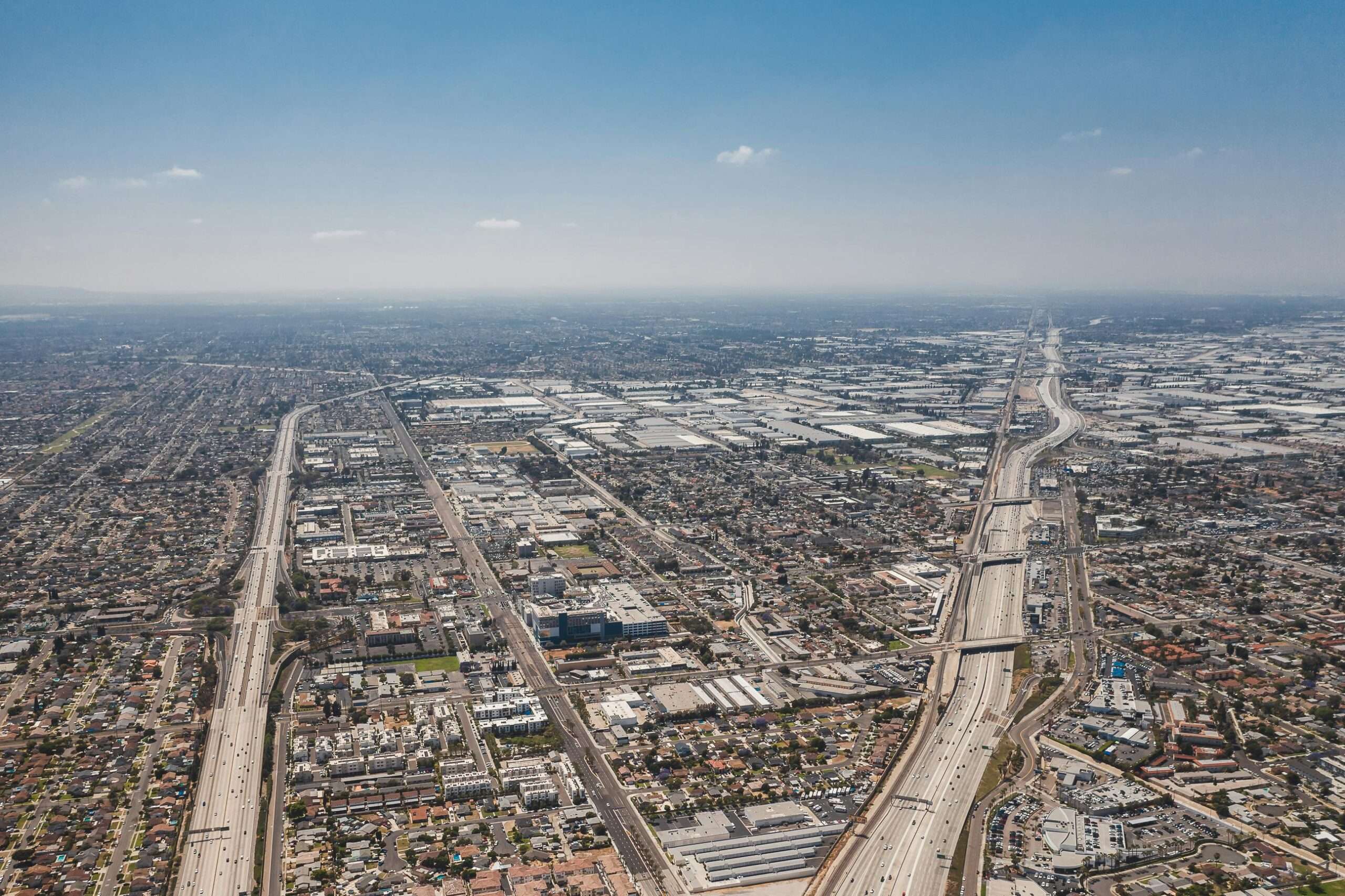 An angled aerial view of Los Angeles highways and neighborhoods.